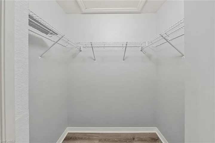 Alcove featuring white wire shelving, wood-finish flooring, and white baseboards