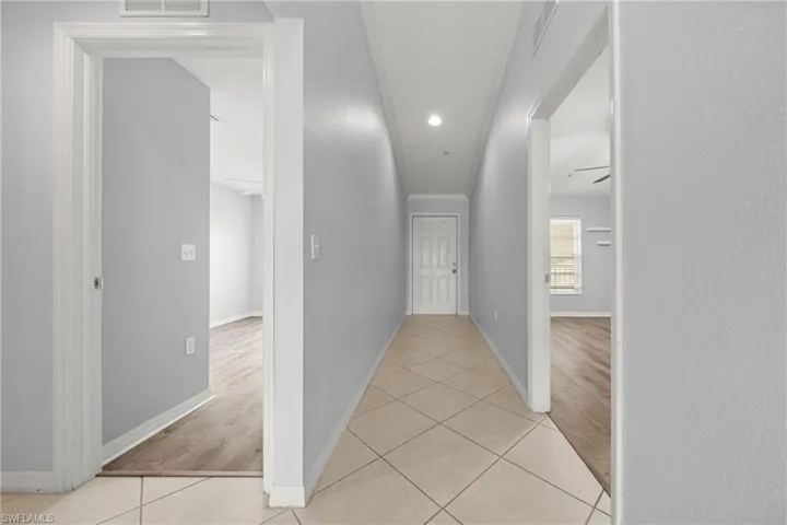 Neutral-toned hallway featuring diagonal tile flooring and recessed lighting