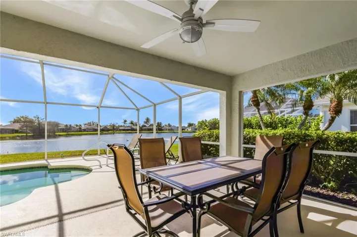 View of patio with a ceiling fan, a residential view, an outdoor pool, glass enclosure, and outdoor dining space