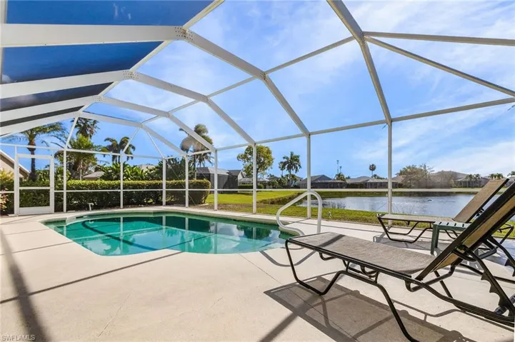 Swimming pool with a sunroom, glass enclosure, a patio, a residential view, and a water view