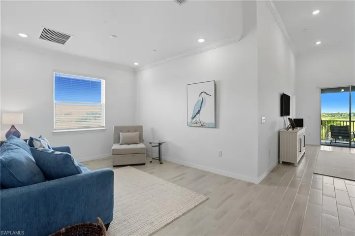 Living area featuring crown molding, light wood finished floors, and recessed lighting