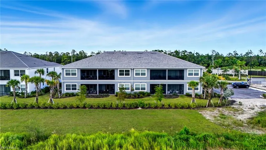 Back of property featuring a lawn and a sunroom