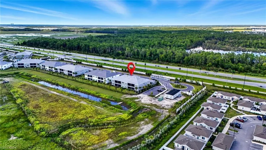 Aerial perspective of suburban area with a nearby body of water and a forest