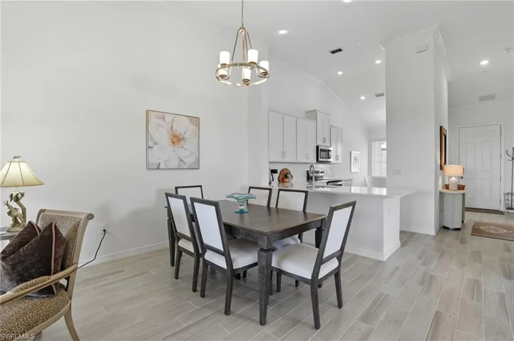 Dining room featuring ornamental molding, wood tiled floors, recessed lighting, and a chandelier