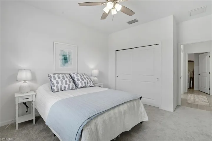 Bedroom with light carpet, a closet, and ceiling fan