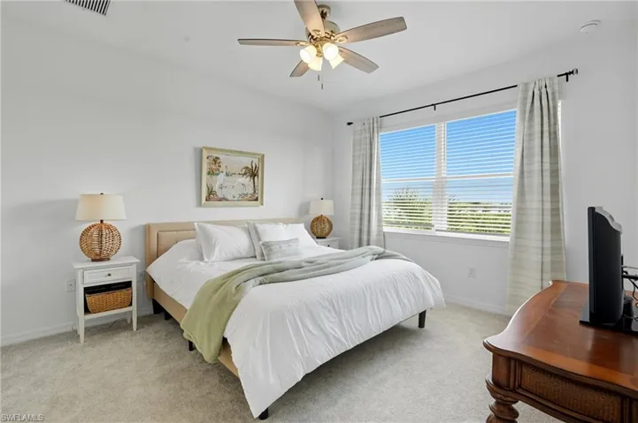 Carpeted bedroom featuring baseboards and ceiling fan