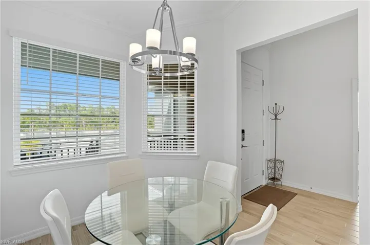 Dining room with light wood-style floors, ornamental molding, and a chandelier