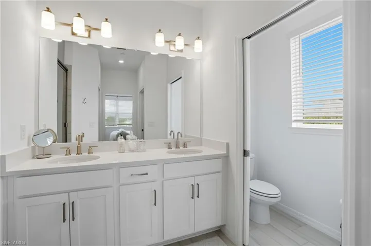 Full bathroom with double vanity and a stall shower