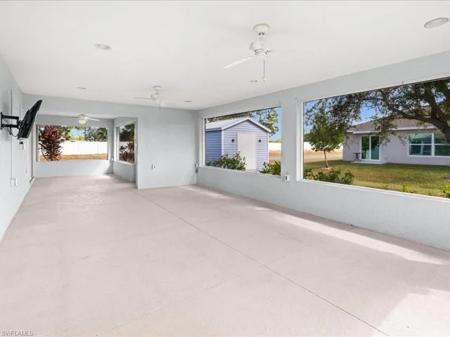 View of patio featuring a ceiling fan, a sunroom, and an outbuilding