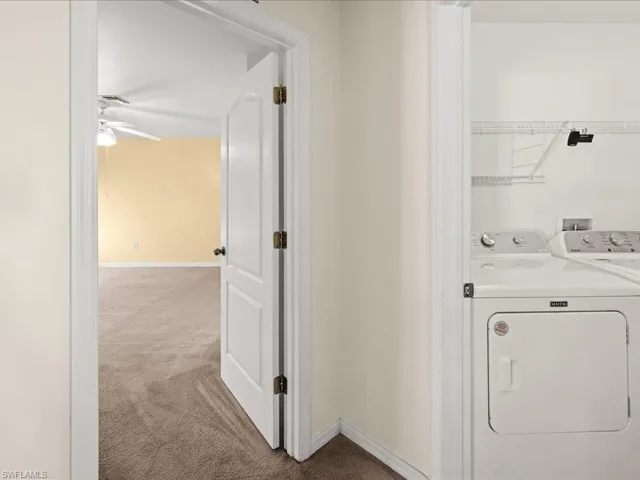 Laundry area featuring carpet floors, washer and dryer, and a ceiling fan