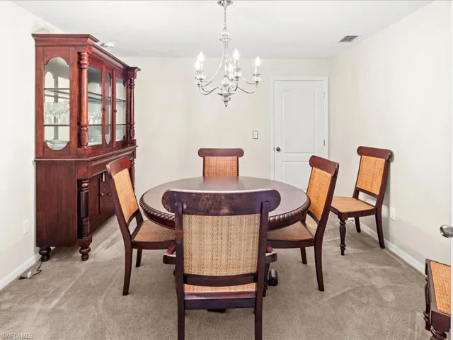 Dining space featuring a chandelier and light carpet