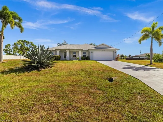 Ranch-style home with concrete driveway, an attached garage, and stucco siding