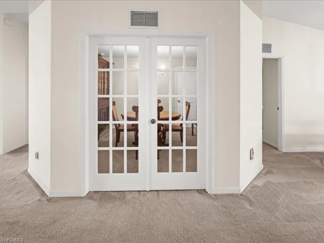 Detailed view of french doors and carpet flooring