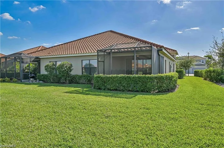 Rear view of house with a yard and a lanai