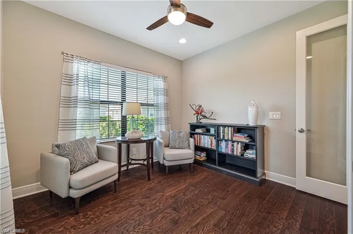 Sitting room with ceiling fan and dark hardwood / wood-style flooring
