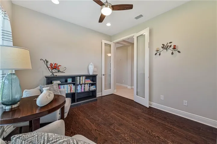 Living area with french doors, dark hardwood / wood-style floors, and ceiling fan