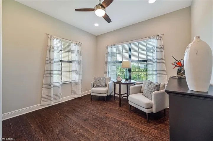 Sitting room featuring ceiling fan and dark wood-type flooring