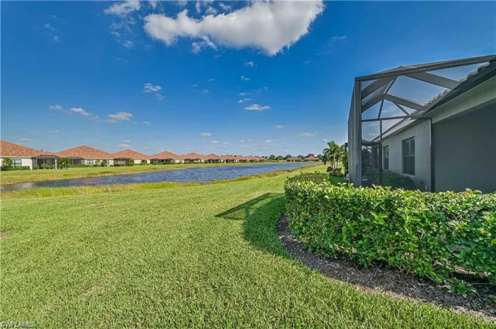 View of yard featuring a water view and glass enclosure