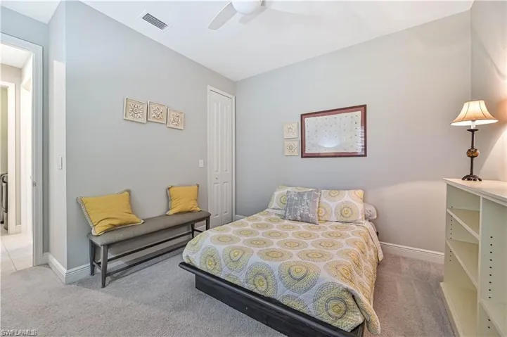 Bedroom with light carpet, a closet, and ceiling fan