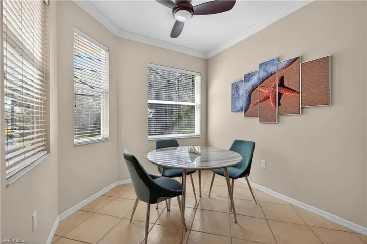 Breakfast area with crown molding, light tile patterned floors, and ceiling fan