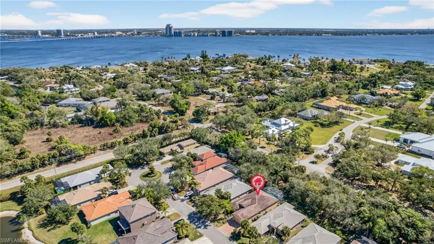 Aerial perspective of suburban area with a large body of water and a notable bridge