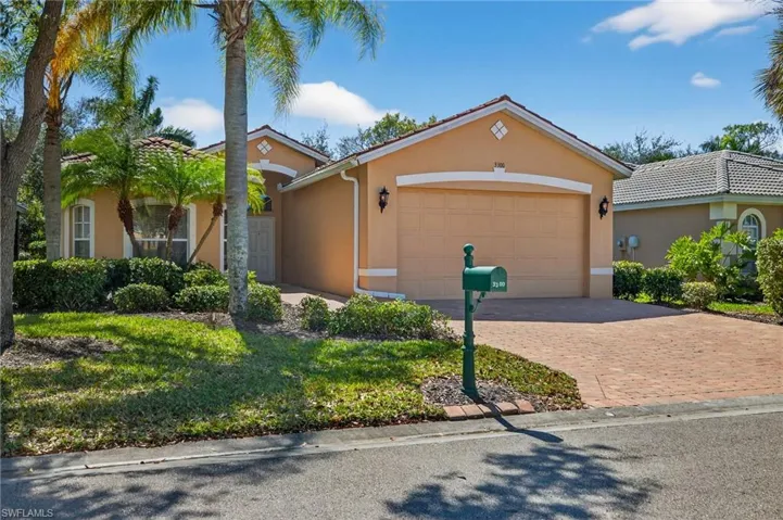 View of front of house with stucco siding, driveway, an attached garage, and a front lawn