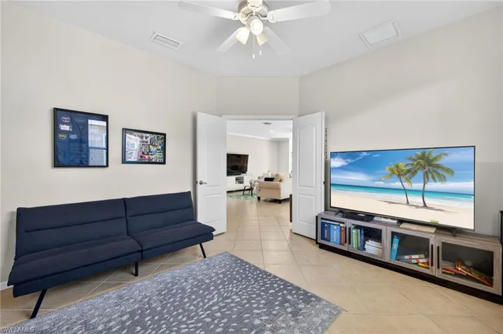 Living area with ceiling fan and light tile patterned floors