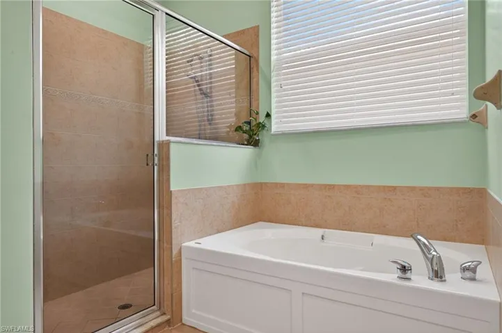 Full bath featuring a stall shower and a garden tub