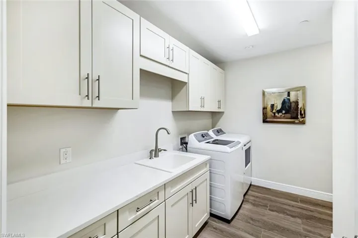 Ample cabinetry, laundry sink, back door access