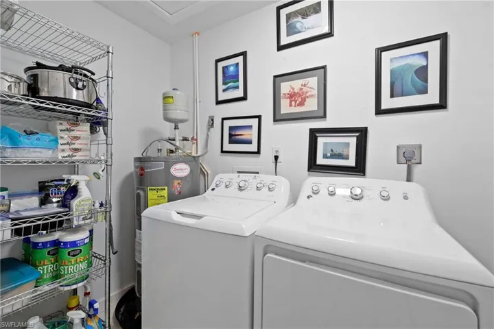 Laundry room featuring washing machine and dryer and electric water heater