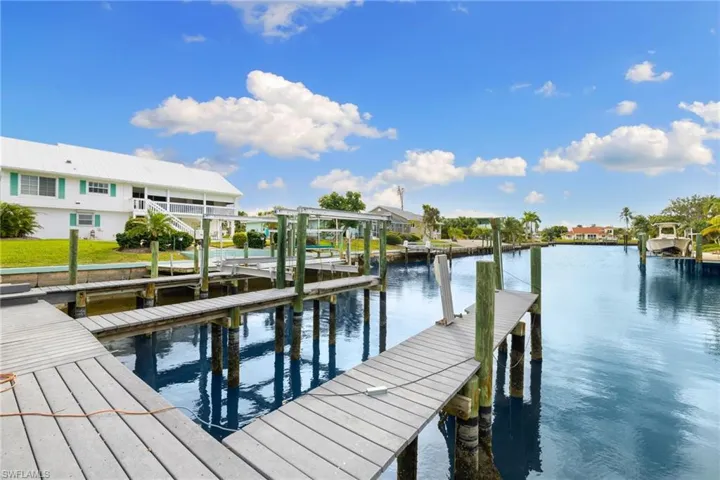 Dock area featuring boat lift, a water view, and a residential view