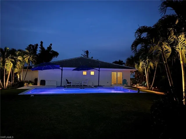 Rear view of house with a yard, an outdoor pool, and a patio