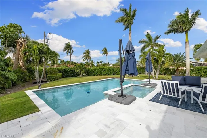 View of pool with a yard, a patio, and a pool with connected hot tub