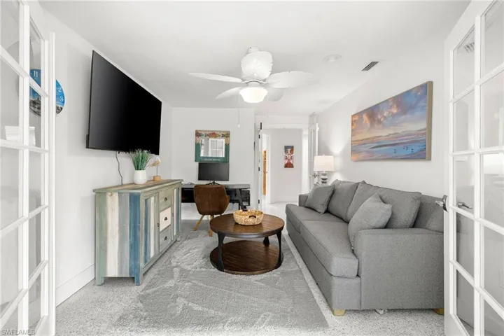 Living room featuring a ceiling fan and light carpet