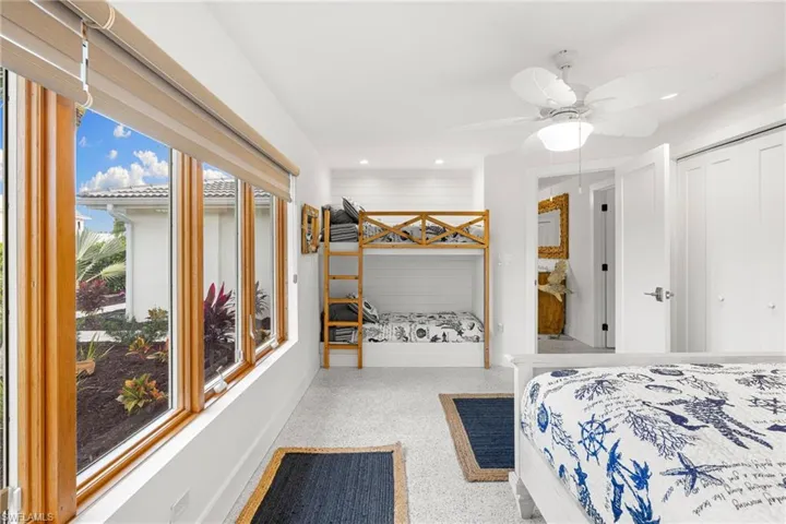 Bedroom featuring dark aggregate flooring, ceiling fan, recessed lighting, and a closet