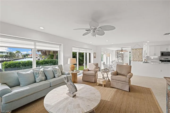 Living room featuring carpet flooring, recessed lighting, a water view, and ceiling fan