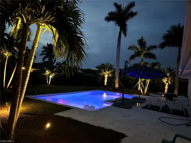 Outdoor pool with a patio area, a jacuzzi, and a yard