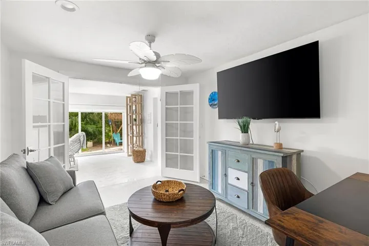 Living room with french doors, a ceiling fan, and carpet flooring