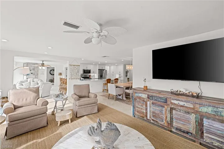 Living room with recessed lighting, ceiling fan, and light colored carpet