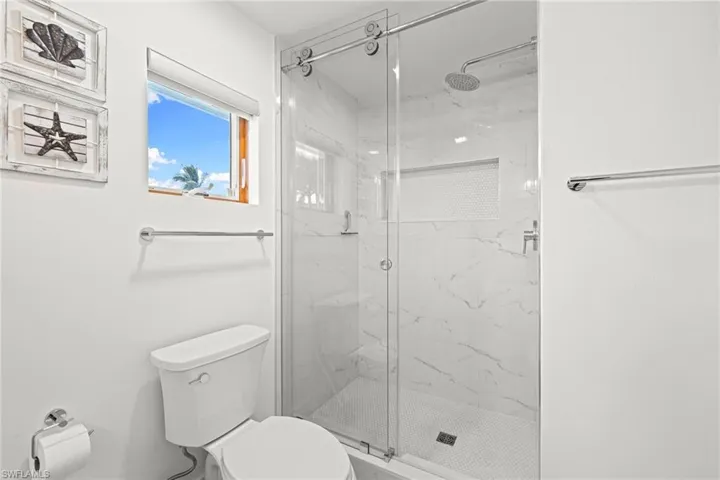 Full bath with a marble finish shower