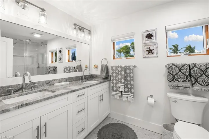 Full bathroom featuring a stall shower and double vanity