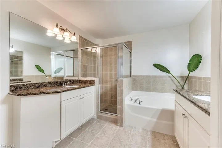 Master bathroom featuring vanity, a garden tub, a stall shower, and tile patterned flooring
