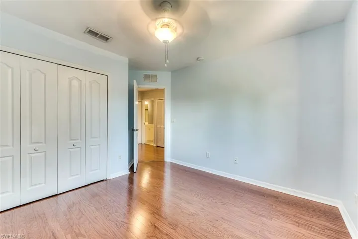 Bedroom featuring wood finished floors, a closet, and a ceiling fan
