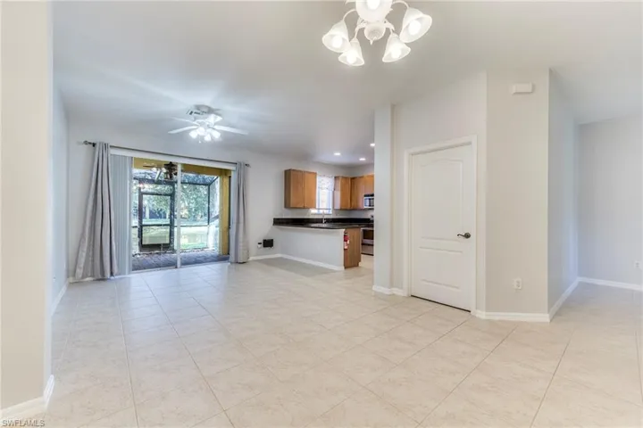 Unfurnished living room with a chandelier, light tile patterned floors, a ceiling fan, and recessed lighting