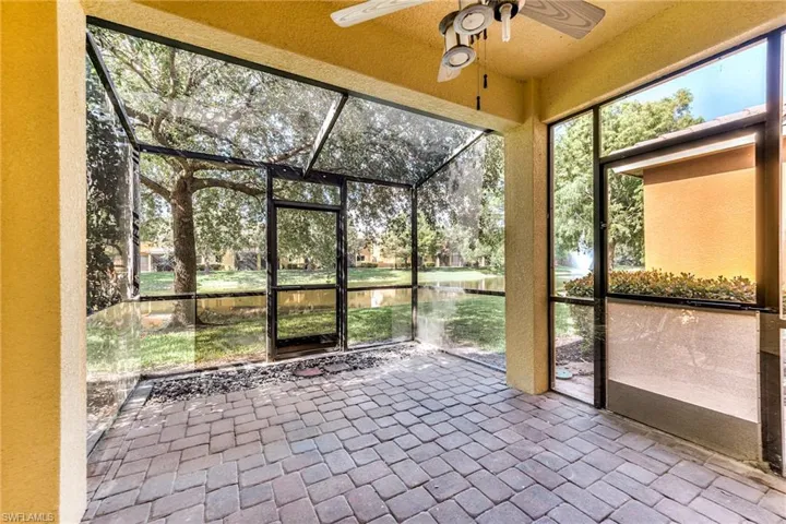 Extended screened lanai featuring a ceiling fan and a water view