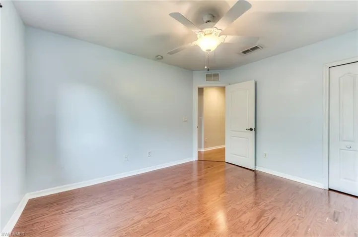 Bedroom featuring wood finished floors, a closet, and ceiling fan