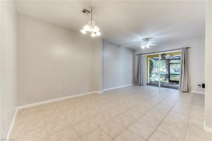 Unfurnished room featuring a chandelier, light tile patterned floors, and ceiling fan