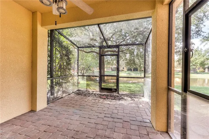 Extended screened lania with ceiling fan, a water view, and healthy amount of natural light