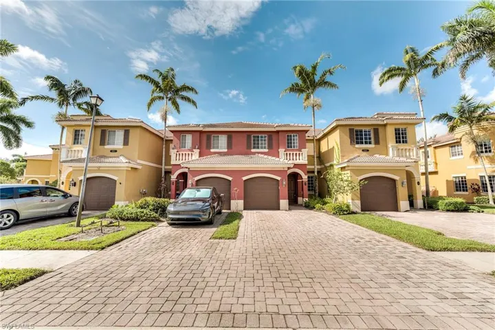Mediterranean / spanish-style home featuring an attached garage, decorative driveway, stucco siding, and a tiled roof