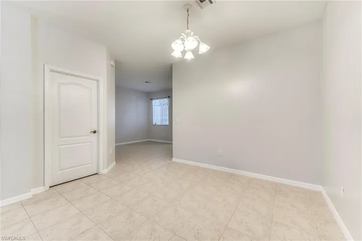 Empty room with a chandelier and baseboards